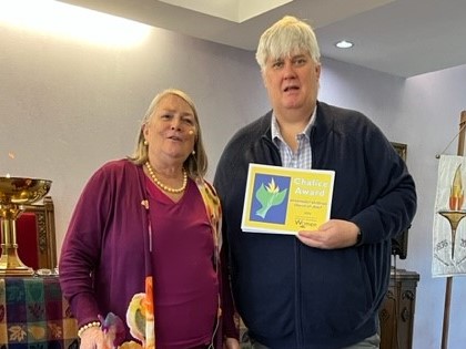Ray Thom President of UU Church Joliet IL receives the Chalice Award from outreach co-chair Rev. Denise Tracy