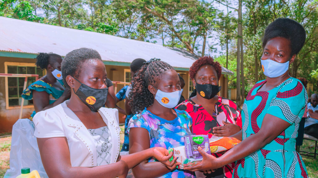 4 women in bright colorful dresses wearing masks