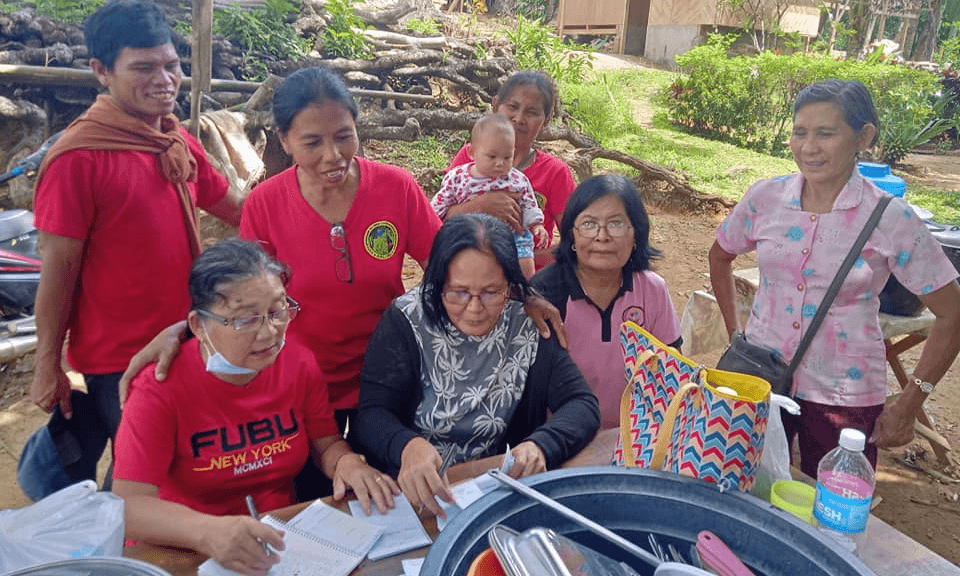 Filipina participants in program - 7 people around a table looking at papers