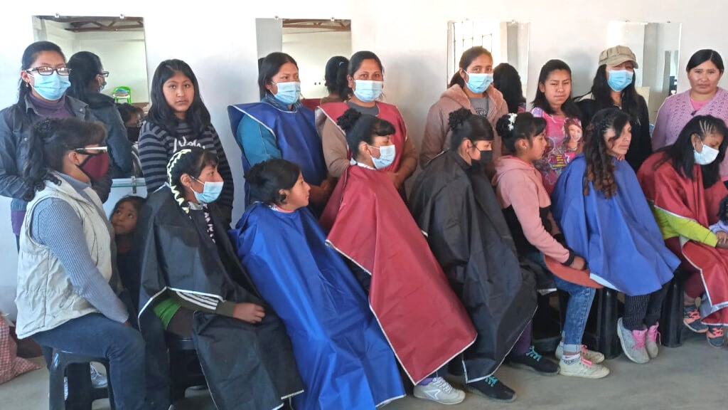 Hairdressing Workshop Participants - 7 women standing behind 7 more women who have just had their hair styled