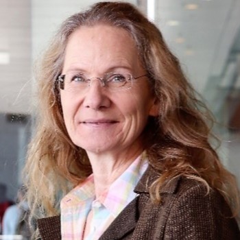 Tina Huesing - portrait of a woman waering glasses, with long blonde hair and a pleasant smile